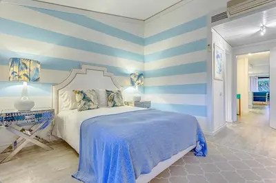 a bedroom with blue and white striped walls and a bed at THE LAKERS Boutique Apartment in Quinta do Lago