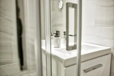a white bathroom with a sink and a mirror at THE LAKERS Boutique Apartment in Quinta do Lago