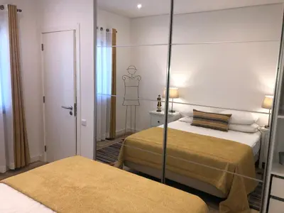 a hotel room with two beds and a mirror at Apartamento 24 SOL in Vilamoura