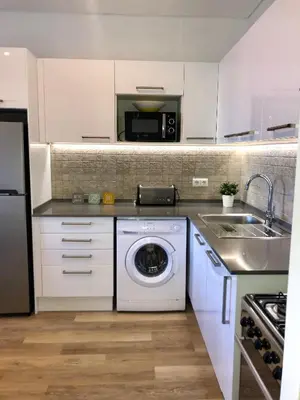 a kitchen with a washing machine and a sink at Apartamento 24 SOL in Vilamoura
