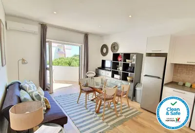 a kitchen and a living room with a table and chairs at Apartamento 24 SOL in Vilamoura