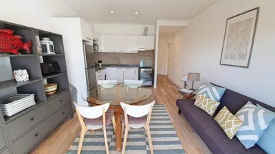 a living room with a glass table and a couch at Apartamento 24 SOL in Vilamoura