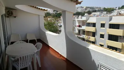 a balcony with a table and chairs and a building at Edificio Albufeira Apartamentos A. Local - Albuturismo Lda in Albufeira