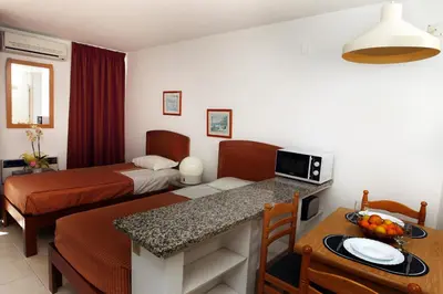 a hotel room with a bed and a dining room at Edificio Albufeira Apartamentos A. Local - Albuturismo Lda in Albufeira