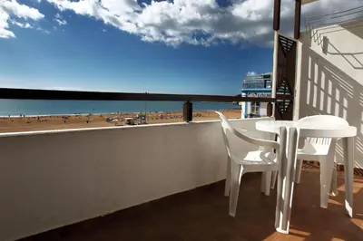 a balcony with a table and chairs and a view of the beach at Edificio Albufeira Apartamentos A. Local - Albuturismo Lda in Albufeira