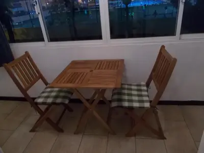 a wooden table and two chairs sitting next to a window at Bellavista Studio in Albufeira