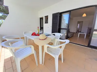 a white dining room with a table and chairs at Sol Nascente- Piscina, Wifi, Familiar in Vilamoura
