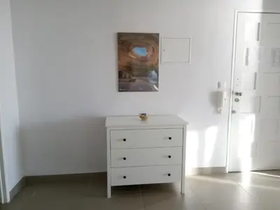 a white dresser in a room with a painting on the wall at Mamamia AC&Vista Magnifica in Quarteira