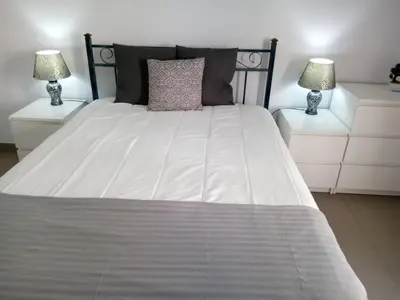 a large white bed with two nightstands and two lamps at Mamamia AC&Vista Magnifica in Quarteira