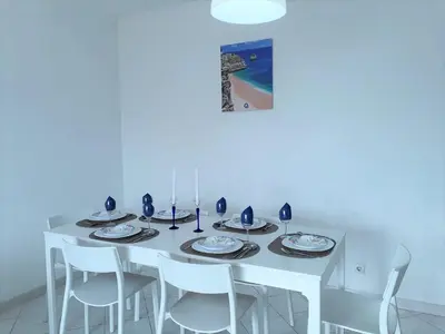 a white dining room table with white chairs at SATÉLITE AC&Garagem in Quarteira