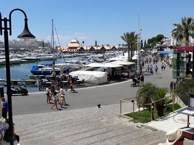 a group of people walking around a marina with boats at V2 Aldeia Do Golf- Piscina, Familiar, Aconchegante in Vilamoura