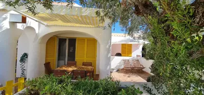 a house with yellow doors and chairs on a patio at V2 Aldeia Do Golf- Piscina, Familiar, Aconchegante in Vilamoura