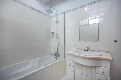 a bathroom with a bath tub with candles and towels at Kiss - Apartamentos in Albufeira