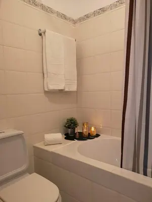 a kitchen with white cabinets and a sink and a microwave at Kiss - Apartamentos in Albufeira