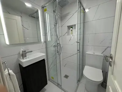 a bathroom with a shower and a toilet and a sink at 3 Bed Holiday Home Lakeside Village Quinta Do Lago in Faro