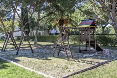 a playground with two swings in a park at FLH Albufeira Açoteias Apartment in Albufeira