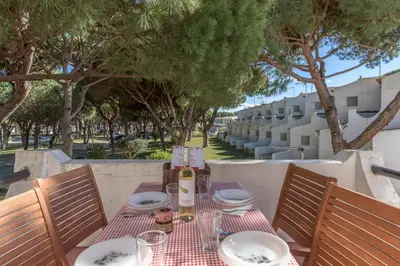 a table with a bottle of wine and plates on it at FLH Albufeira Açoteias Apartment in Albufeira