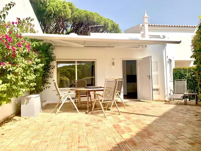 a patio with a table and chairs in front of a house at Beach Villa Vale do Lobo in Vale do Lobo