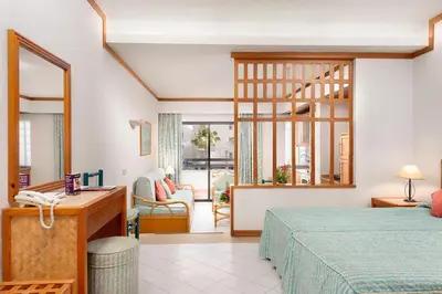 a hotel room with a bed and a desk at Muthu Oura Praia Hotel in Albufeira