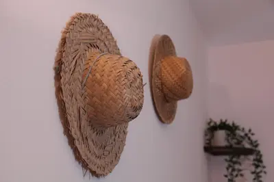 two straw hats hanging on a wall at Casa das Andorinhas in Faro