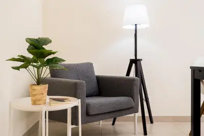 a living room with a chair and a table with a plant at T1 V do Forte AC&Piscina&Garagem in Quarteira