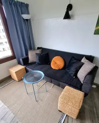 a living room with a blue couch and a table at Tenis Golfmar 409A - pool view in Vilamoura