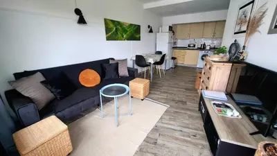 a living room with a blue couch and a kitchen at Tenis Golfmar 409A - pool view in Vilamoura