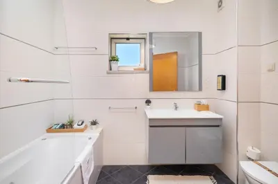 a white bathroom with a sink and a mirror at Loulé Charming in Loulé