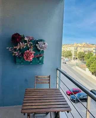 a wooden bench sitting on a balcony with flowers at Loulé Charming in Loulé