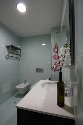 a bathroom with a sink and a vase with flowers in it at Monte da Eira in Albufeira