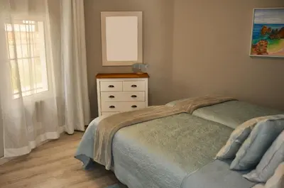 a bedroom with a bed and a dresser and a window at Aquamarine - Gemstone Getaway in Vale do Lobo