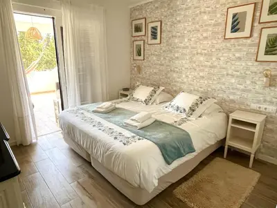 a bedroom with a bed and a brick wall at ExcelStay - Balaia in Albufeira
