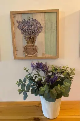 a white vase with purple flowers sitting on a table at ExcelStay - Balaia in Albufeira