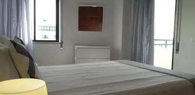 a white bedroom with a bed and a window at Avenida Mar- Vista Mar, Wifi, 150mt Praia in Quarteira