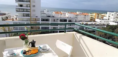 a table with a bowl of fruit and a vase of flowers at Avenida Mar- Vista Mar, Wifi, 150mt Praia in Quarteira