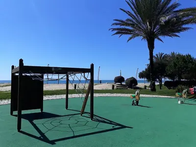 a basketball hoop on a green field with a palm tree at Avenida Mar- Vista Mar, Wifi, 150mt Praia in Quarteira