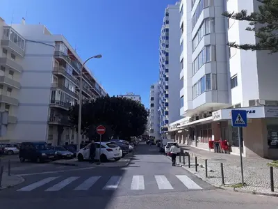 a city street with cars parked on the side of the road at T2 Mira Praia 4- Familiar, 80mt Praia, Wifi in Quarteira