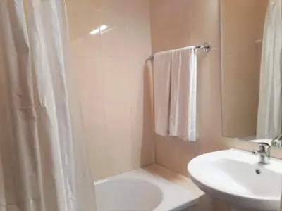 a bathroom with a sink and a shower and a toilet at T2 Mira Praia 4- Familiar, 80mt Praia, Wifi in Quarteira