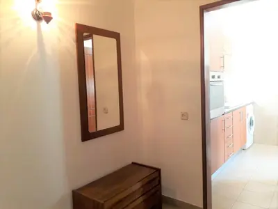 a bathroom with a mirror on the wall and a table at T2 Mira Praia 4- Familiar, 80mt Praia, Wifi in Quarteira