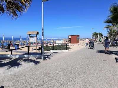 people walking on a beach with the ocean in the background at T2 Mira Praia 4- Familiar, 80mt Praia, Wifi in Quarteira