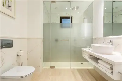 a bathroom with a shower and a toilet and a sink at Pine Cliffs Gardens in Albufeira