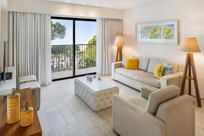 a living room with a couch and a table at Pine Cliffs Gardens in Albufeira