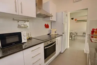 a kitchen with white cabinets and a microwave at Son of a Beach Hostel in Albufeira