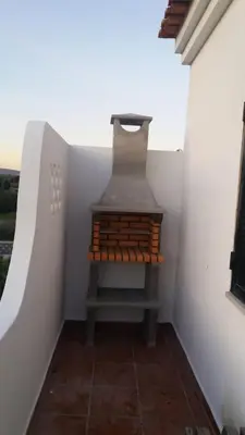 a small room with a stove in a white wall at Quinta Shiamar in Quarteira