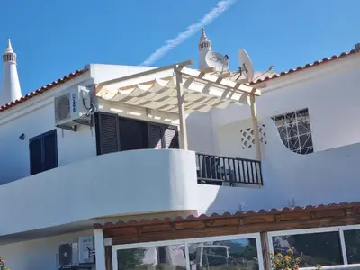 a white house with a pergola at Quinta Shiamar in Quarteira