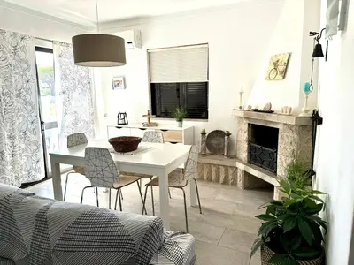 a living room with a table and a fireplace at Quinta Shiamar in Quarteira