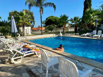 a man is sitting in a swimming pool at Quinta Shiamar in Quarteira