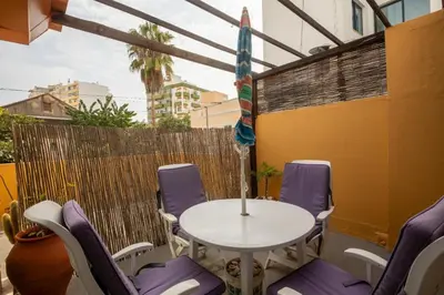 a patio with a table and chairs and an umbrella at Rua Fancisco Barreto in Faro