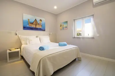 a bedroom with a large white bed and a window at Apartamento Villa Bellevue vista mar in Albufeira