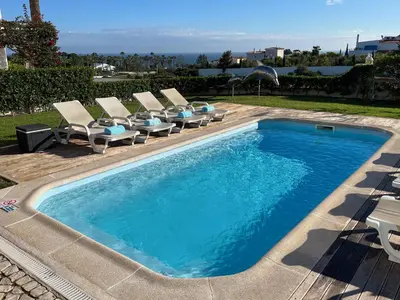 a swimming pool with chaise lounge chairs and a swimming pool at Apartamento Villa Bellevue vista mar in Albufeira
